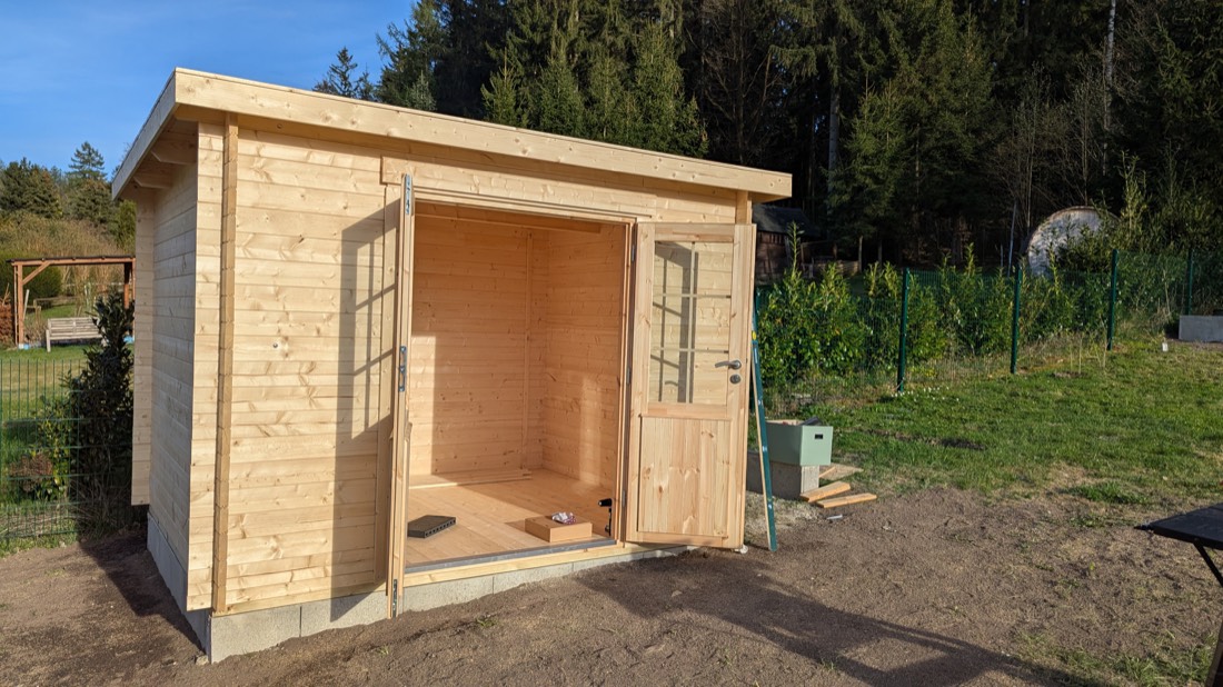 Hochwertiges Gartenhaus mit Pultdach und geöffneter Tür